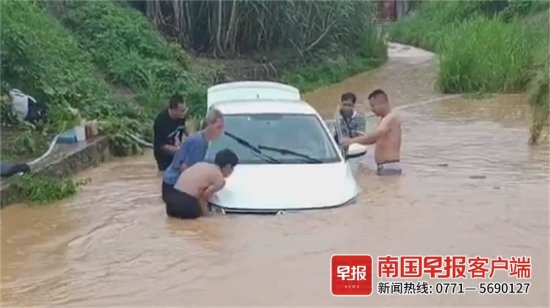 汽车被暴涨<em>的洪水</em>围困，路过的他们出手将车抢救了出来