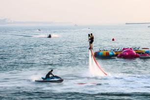 <em>青岛</em>：游客与浪共舞 体验海上运动乐趣