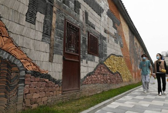 重庆街头现巨型缤纷石彩墙 展示吊脚楼棒棒军等巴渝文化