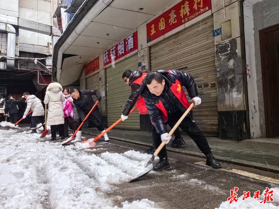 汉正街党员商户推迟回家，清晨就在社区扫雪开路