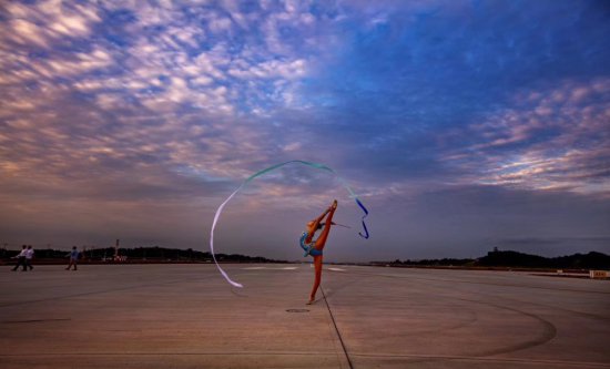 拍艺术体操美女在天府机场跑道中间伴着彩霞烟花起舞