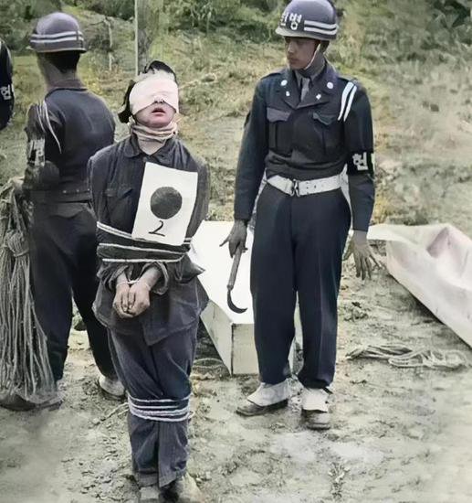 1949年韩国济州岛，一名<em>女犯人</em>正等待处决，身边放置着薄木棺材