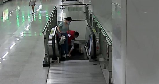 女乘客在电梯上突然栽倒，红衣大哥箭步上前将其抱起